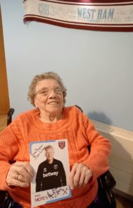 Lady sitting with a signed photo of a footballer