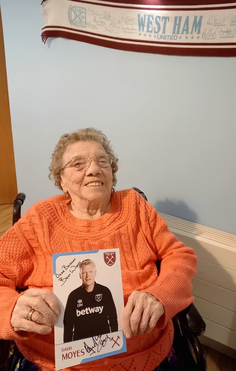 Lady sitting with a signed photo of a footballer