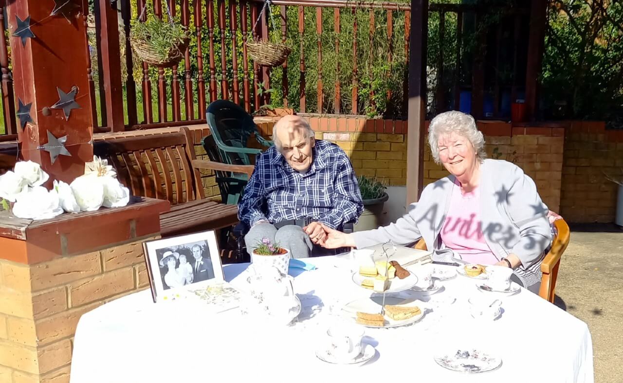 couple sitting in a garden having afternoon tea